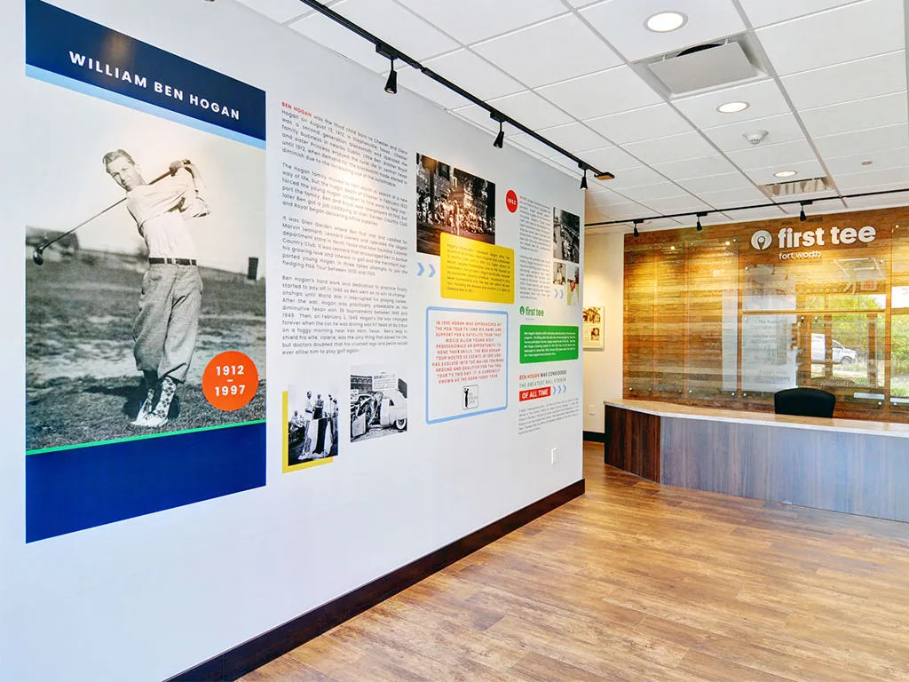 William Ben Hogan biographical wall at the Ben Hogan Learning Center with a black-and-white portrait of Hogan, life timeline marked 1912 to 1997, and the wooden reception desk in view