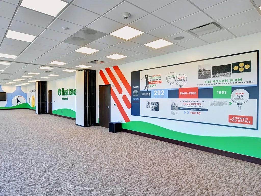 Interior hallway view of the Ben Hogan career statistics wall with the red angled stripe pattern, 'Was Ben Hogan the Greatest Golfer That Ever Lived?' headline, and the 292 PGA tournament stat