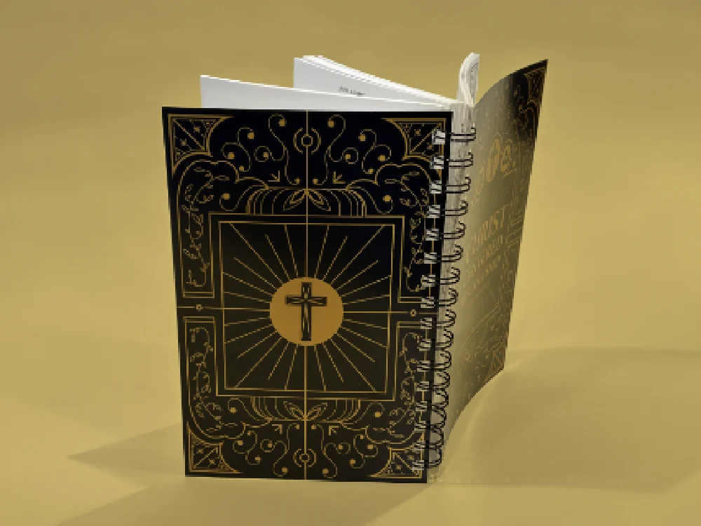 Christ Centered Discipleship book standing open to show the gold-on-black back cover featuring an ornate frame and central cross illustration