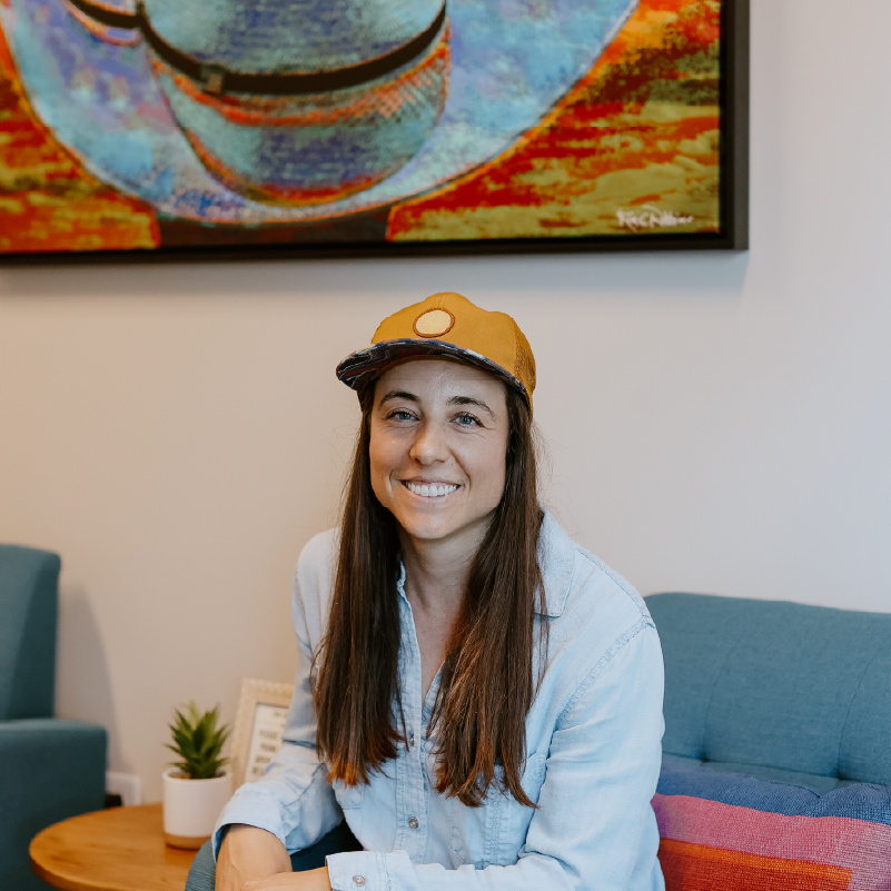 Smiling portrait of a team member in an orange cap and chambray shirt in the Creative Manufacturing office