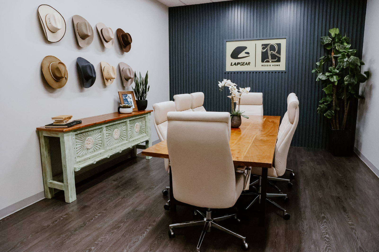 Creative Manufacturing conference room with cowboy hat wall, framed child brand logos, and a wood conference table