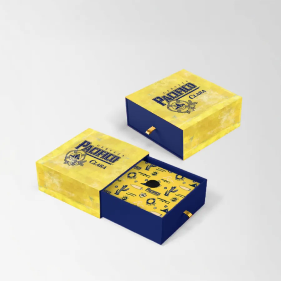Pacifico Cerveza Clara presentation box in yellow and blue with gold accents and an interior pattern of cacti, surfboards, and Pacifico icons