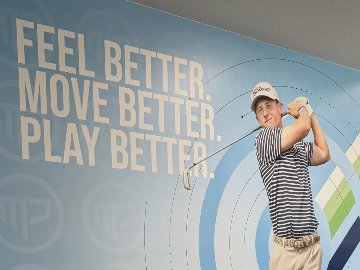 Close-up of the 'Feel Better. Move Better. Play Better.' vinyl wall with a life-size golfer mid-follow-through