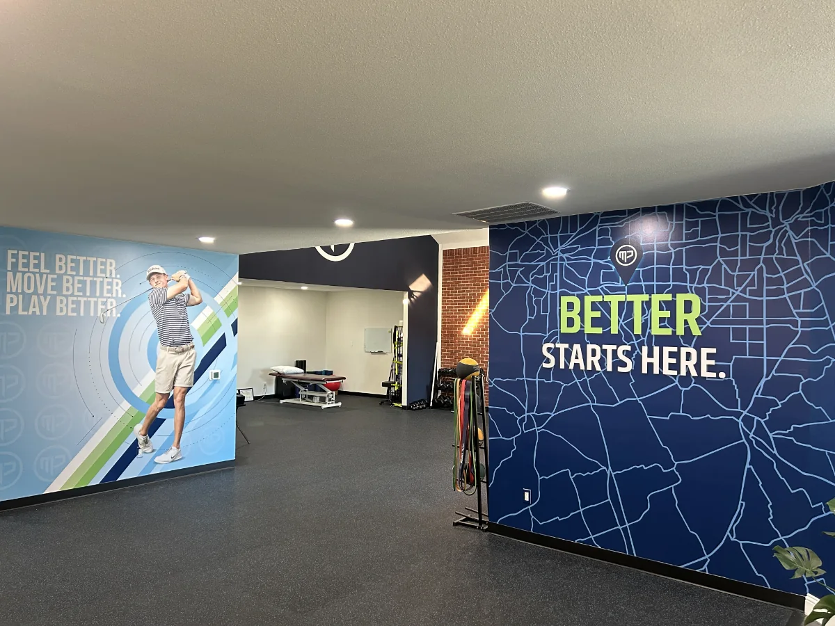 Wide interior view of the MyPhysio studio showing both vinyl wall installs and the treatment area between them