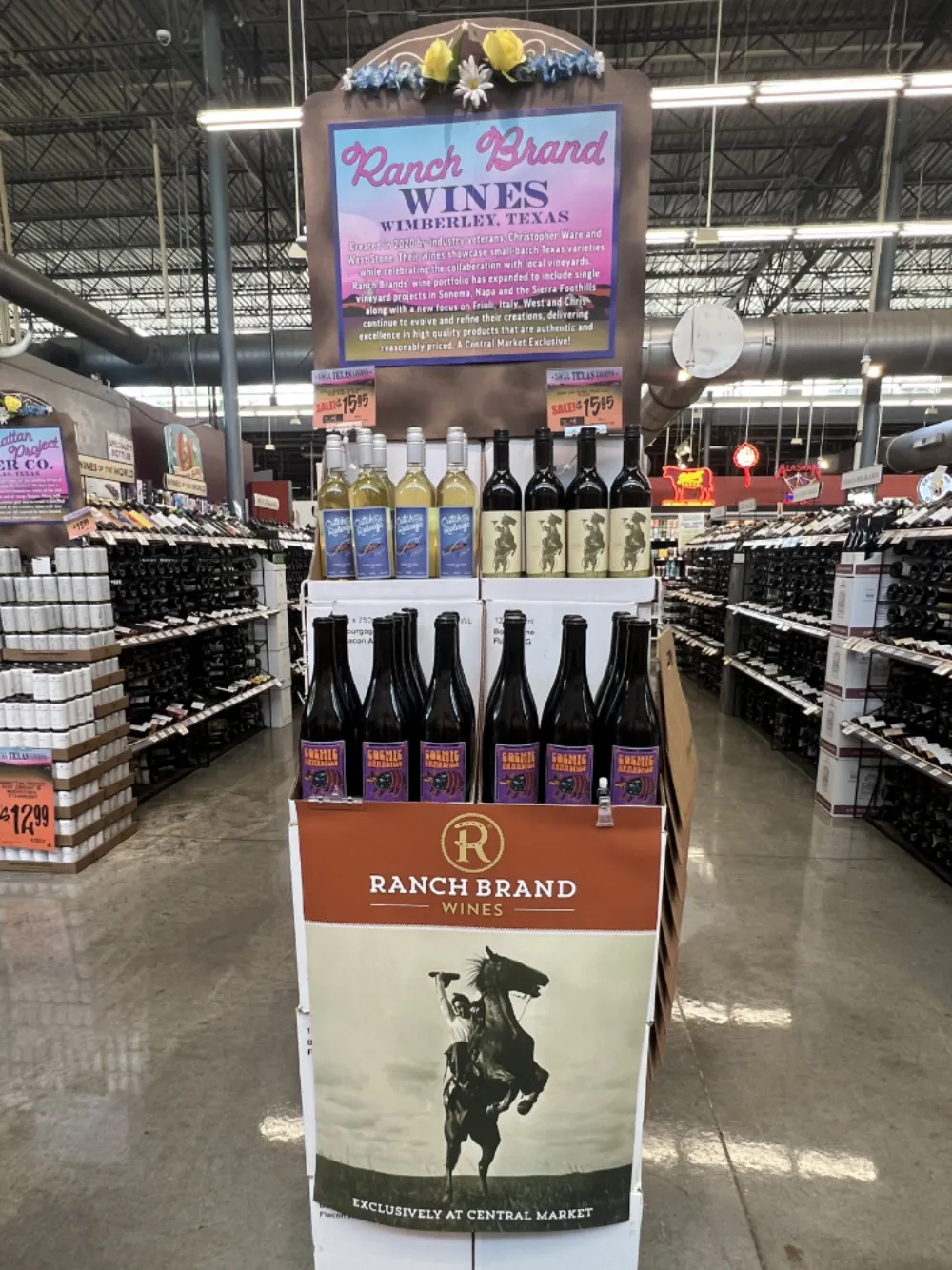 Ranch Brand Wines in-store display at Central Market with a Wimberley, Texas header poster and multiple wine bottles stacked on shelves